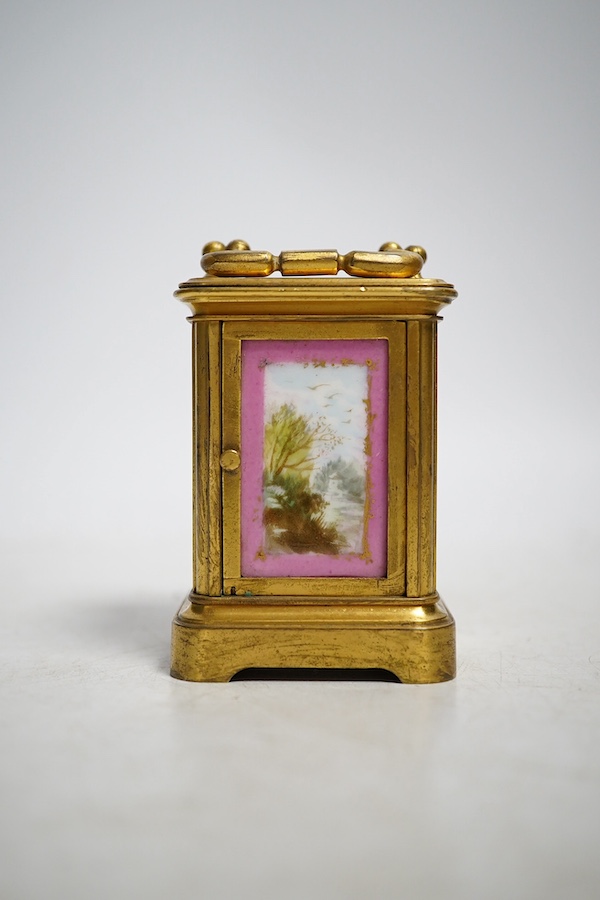 A miniature brass and enamel figurative panelled carriage timepiece, 7cm high. Condition - both gilt and enamel panels marked